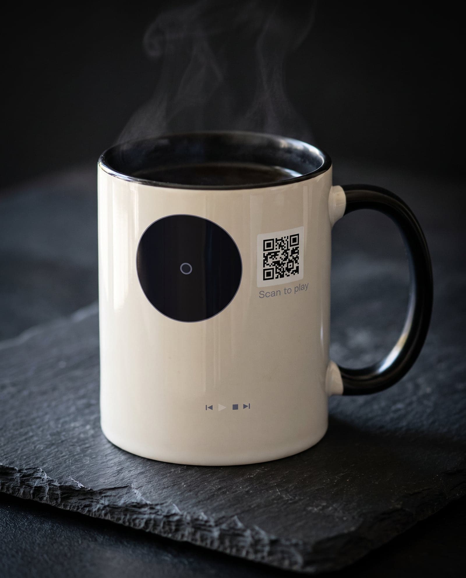 A mug printed with a vinyl record and a scan code, steaming on a slate counter